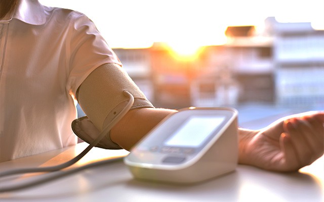 Person misst seinen Blutdruck mit einem elektronischen Blutdruckmessgerät